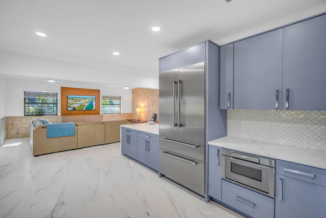 kitchen featuring built in appliances and backsplash