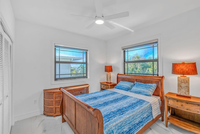 bedroom with multiple windows, ceiling fan, and a closet