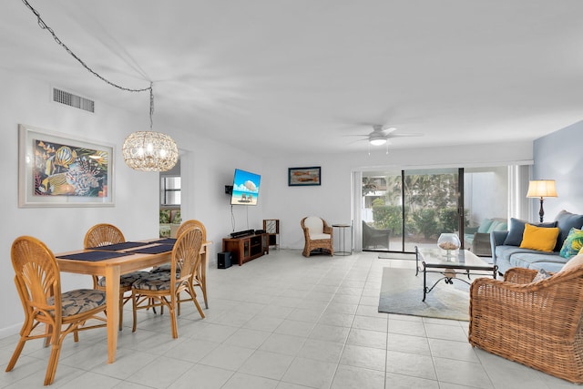 dining room with ceiling fan with notable chandelier and light tile patterned floors