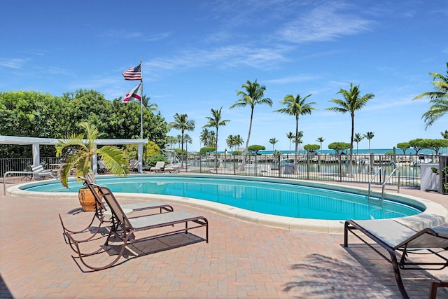 view of pool featuring a patio and a water view