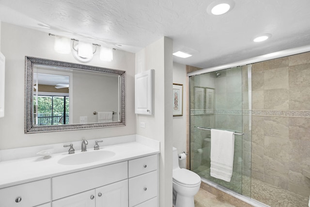 bathroom featuring vanity, an enclosed shower, a textured ceiling, and toilet