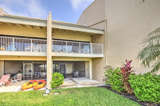 1133 W Ocean Dr Unit 2, Key Colony, FL 33051 - rear view of house with a lawn, stucco siding, and a patio area