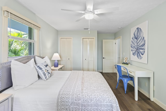 bedroom featuring ceiling fan, dark hardwood / wood-style floors, and multiple closets