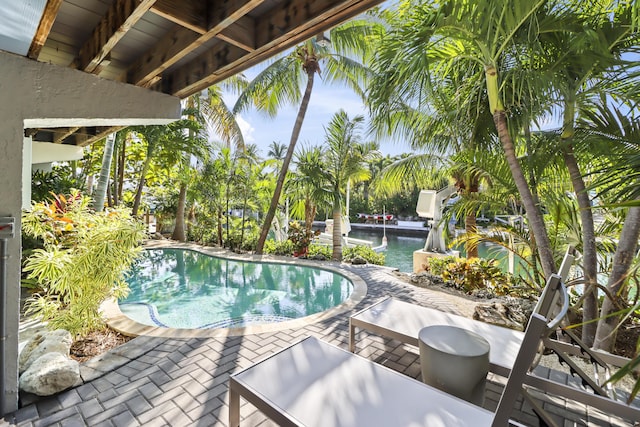 view of swimming pool featuring a patio area and a water view