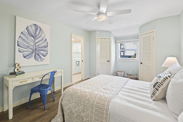 bedroom with ceiling fan, ensuite bathroom, a textured ceiling, dark hardwood / wood-style flooring, and multiple closets