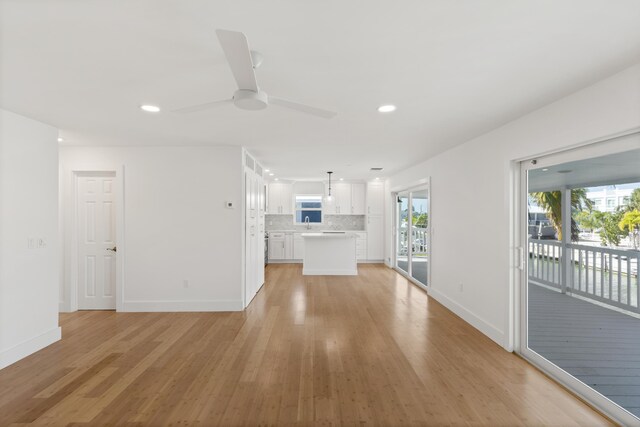 unfurnished living room with ceiling fan and light wood-type flooring