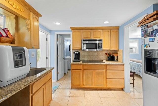 kitchen with stainless steel appliances, light stone countertops, sink, and decorative backsplash