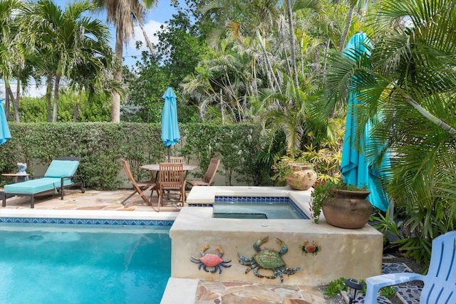 view of pool featuring an in ground hot tub and a patio