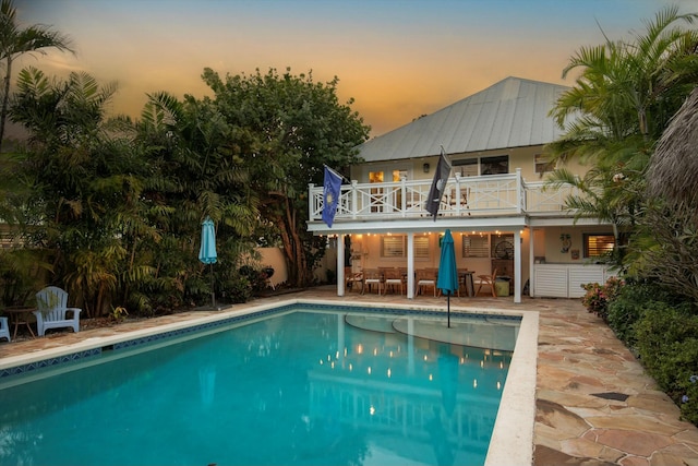 pool at dusk featuring a patio area