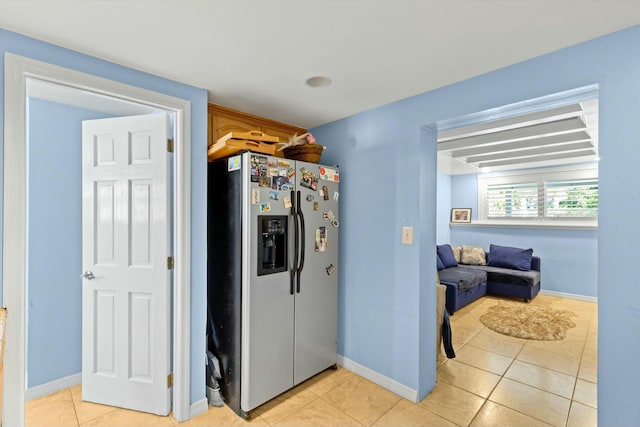 kitchen featuring light tile patterned flooring and stainless steel fridge with ice dispenser