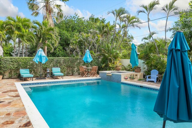 view of swimming pool featuring an in ground hot tub and a patio area