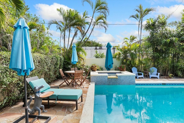 view of swimming pool featuring a patio and a jacuzzi