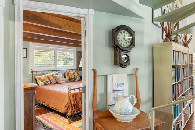 bedroom featuring beamed ceiling and hardwood / wood-style floors