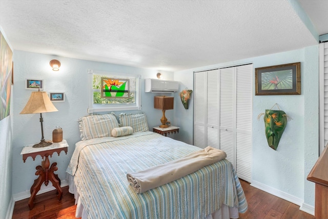 bedroom with an AC wall unit, a textured ceiling, dark hardwood / wood-style flooring, and a closet