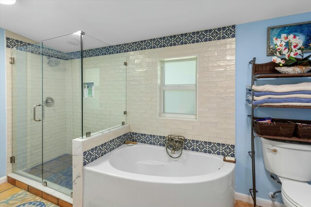 bathroom featuring toilet and separate shower and tub