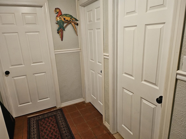 hallway with dark tile patterned flooring