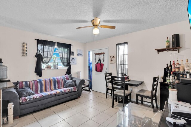 living room with light tile patterned floors, a textured ceiling, and ceiling fan