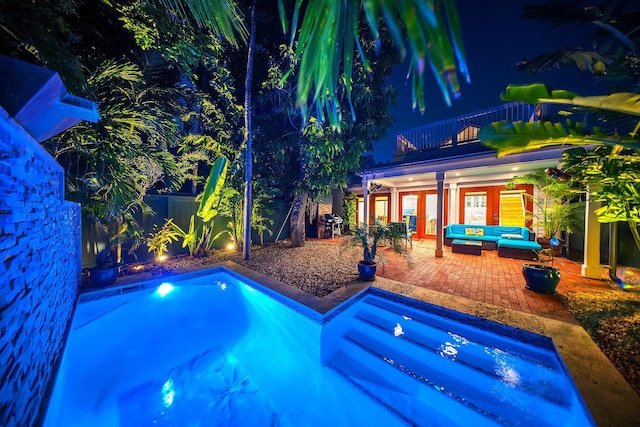 view of pool featuring a patio, an outdoor living space, a hot tub, and french doors