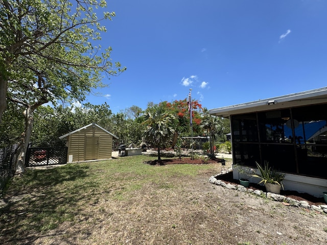 view of yard featuring a sunroom and a storage shed