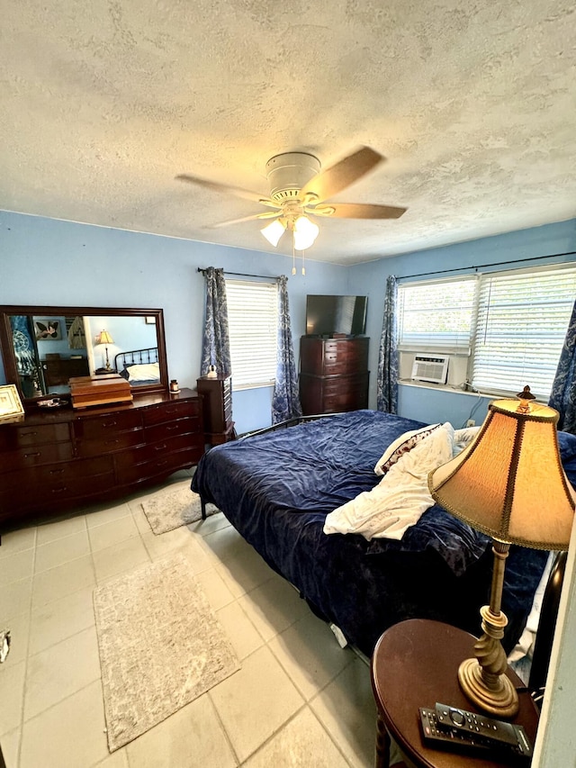 bedroom featuring multiple windows, light tile patterned floors, and a textured ceiling