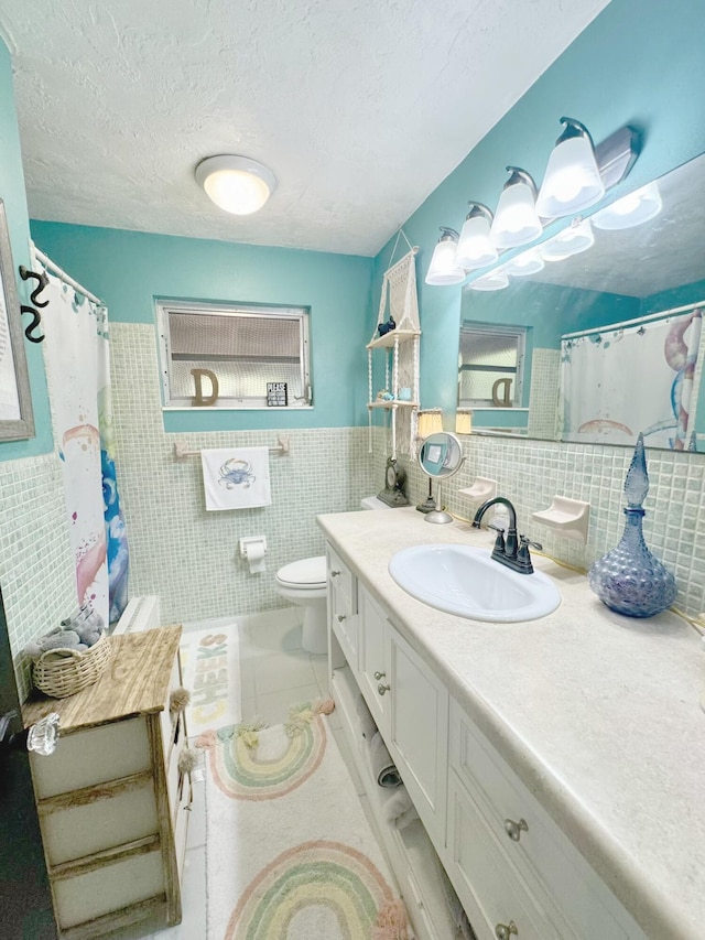 bathroom with toilet, a textured ceiling, tile walls, vanity, and tile patterned flooring