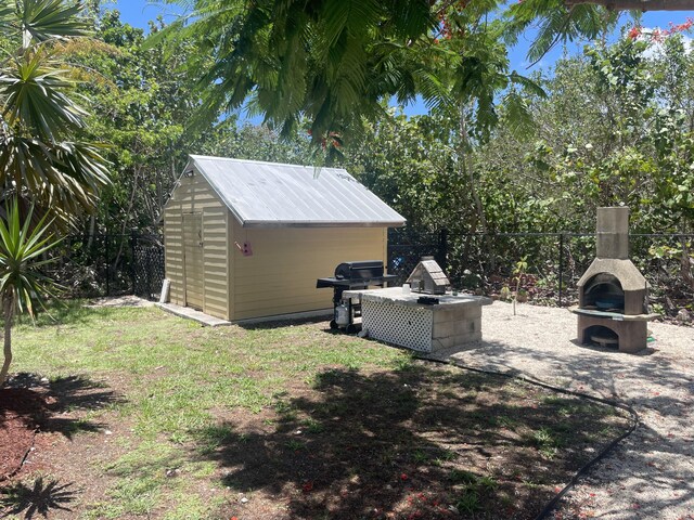 view of yard with an outdoor kitchen and exterior fireplace