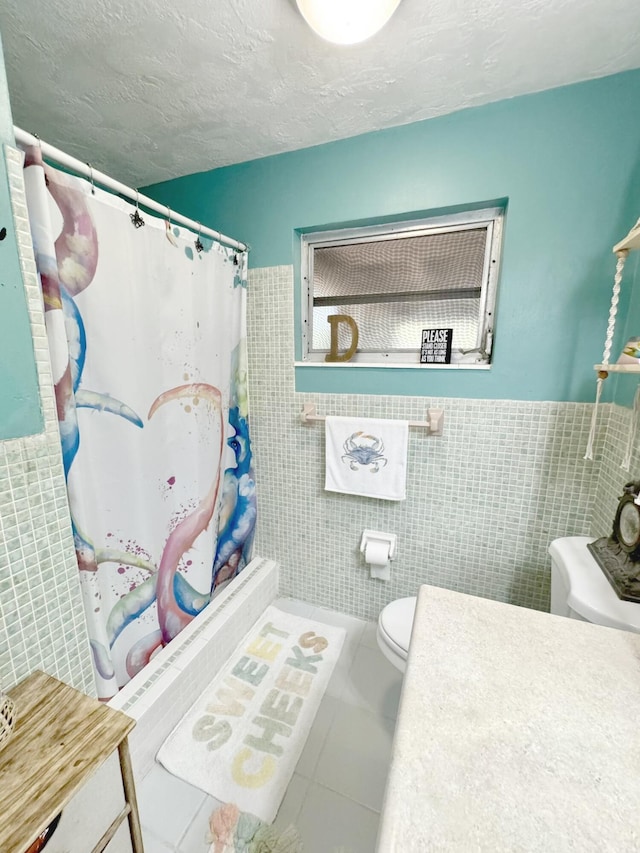 bathroom with walk in shower, toilet, tile walls, a textured ceiling, and tile patterned flooring