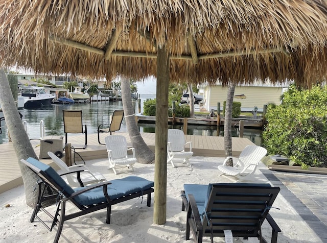 view of patio featuring a water view, a dock, and a gazebo