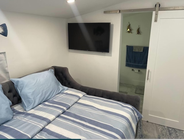 bedroom with vaulted ceiling and a barn door