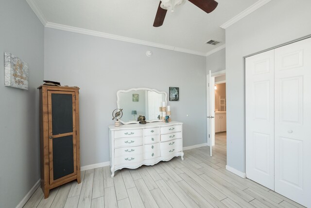 bedroom with wood finish floors, a closet, visible vents, and baseboards