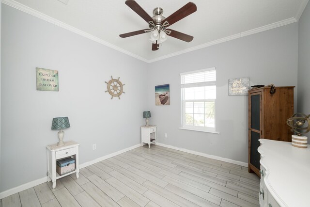 interior space featuring light wood finished floors, a ceiling fan, baseboards, and crown molding