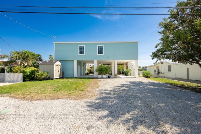 view of front of property with driveway, stairs, an outdoor structure, a shed, and a carport