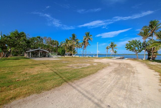 surrounding community featuring a water view and a yard