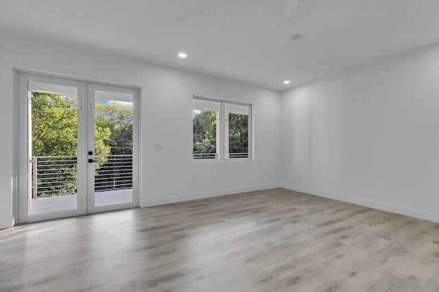 unfurnished room featuring french doors and light hardwood / wood-style flooring