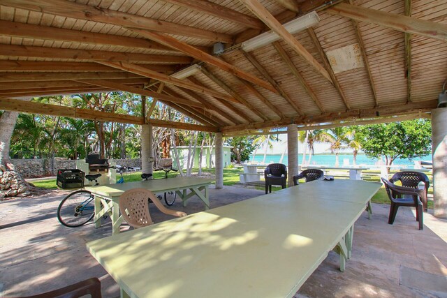 view of patio with a water view, a beach view, and a gazebo