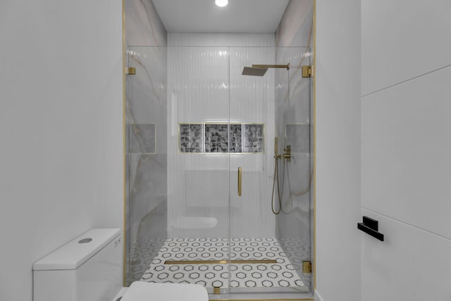 bathroom with a shower with shower door and toilet