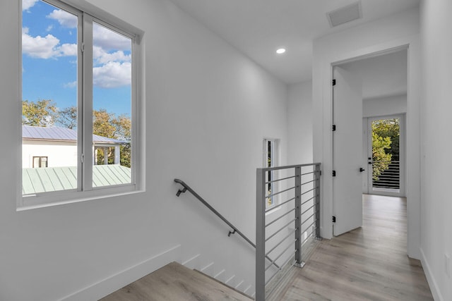 staircase featuring wood-type flooring and plenty of natural light