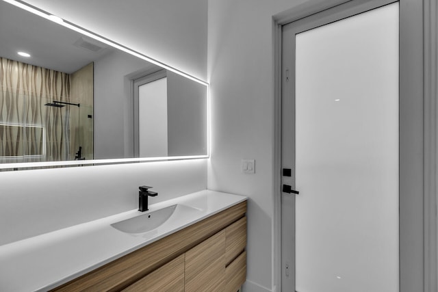 bathroom with vanity and a shower