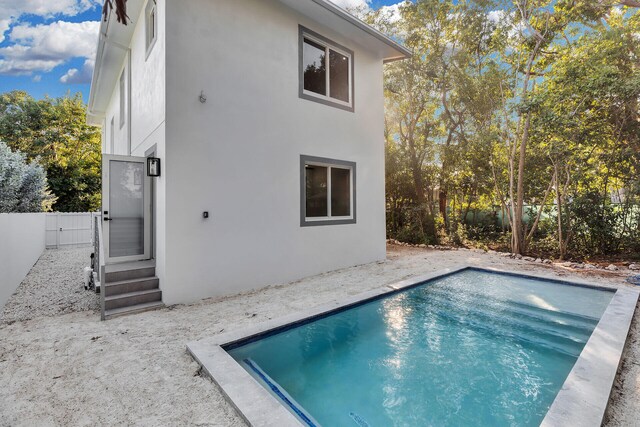 rear view of house featuring a fenced in pool