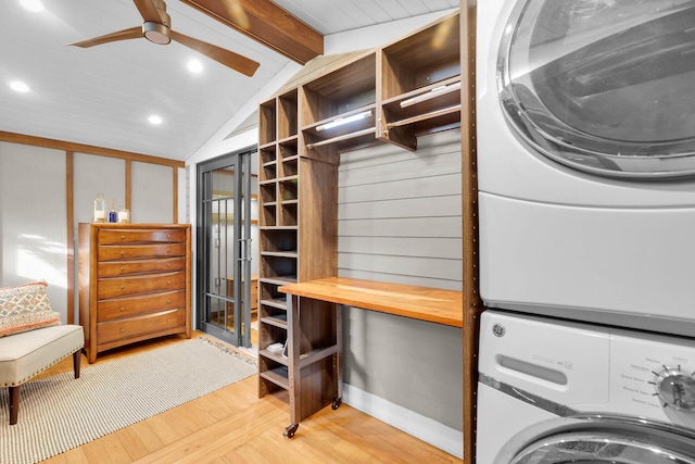 washroom featuring ceiling fan, stacked washing maching and dryer, and light hardwood / wood-style flooring