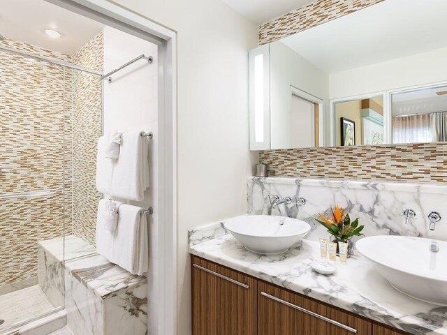 bathroom with vanity, an enclosed shower, and backsplash