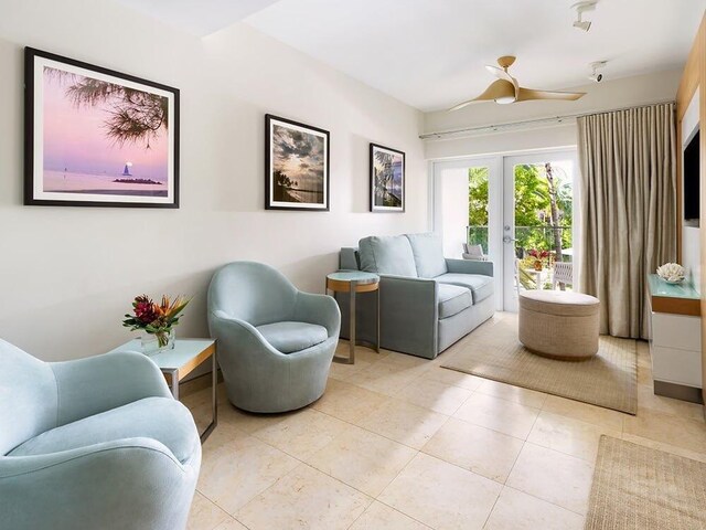 tiled living room featuring ceiling fan and french doors