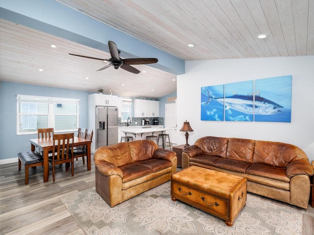 living room featuring lofted ceiling, light hardwood / wood-style flooring, wooden ceiling, and ceiling fan