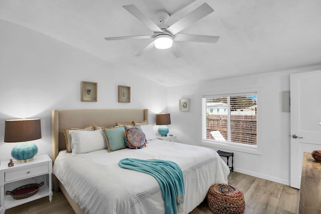 bedroom featuring ceiling fan, lofted ceiling, and light wood-type flooring