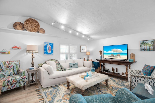 living room featuring hardwood / wood-style flooring, vaulted ceiling, a textured ceiling, and track lighting