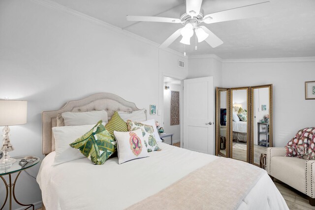 bedroom featuring crown molding, ceiling fan, and light hardwood / wood-style flooring