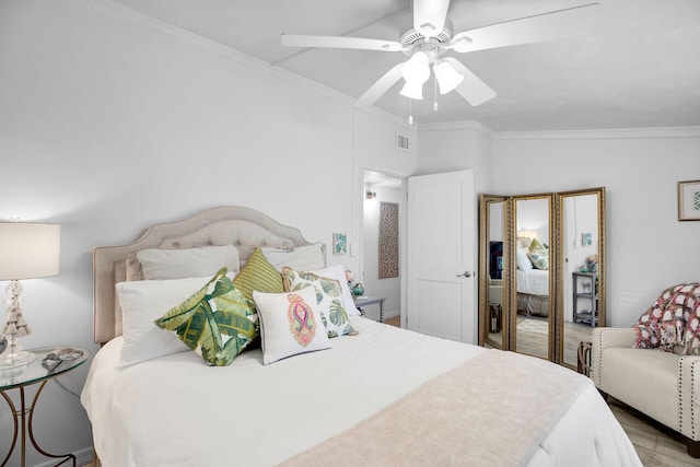 bedroom featuring ornamental molding, vaulted ceiling, ceiling fan, and light wood-type flooring