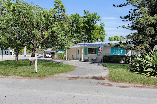 634 Ponce De Leon Blvd, Key Largo, FL 33037 - ranch-style house featuring driveway, a front yard, and stucco siding