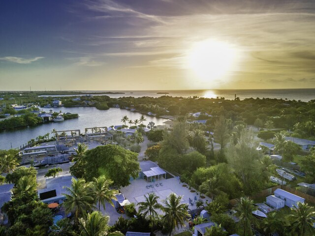 aerial view at dusk featuring a water view