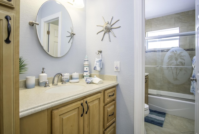 full bathroom featuring vanity, tile patterned flooring, enclosed tub / shower combo, and toilet